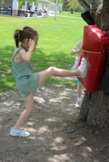 Girl kicking bag on tree